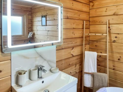 a bathroom with a white sink and a mirror at Coo Lodge - Uk48430 in Falkirk