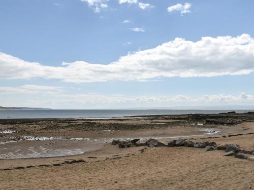 a beach with rocks on the sand and the ocean at Secret Spot in Newton