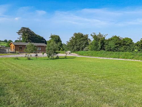 a field of grass with a house in the background at Buckland Lodge in Pentridge