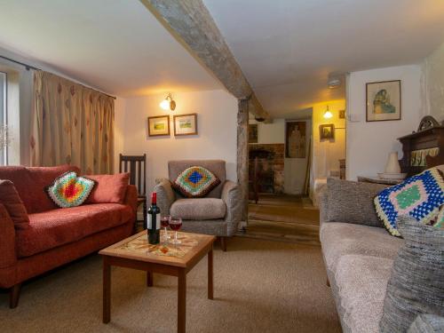a living room with two couches and a table at Avebury Cottage in Avebury