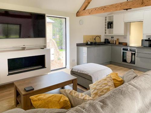 a living room with a couch and a kitchen at The Coach House in Fordingbridge