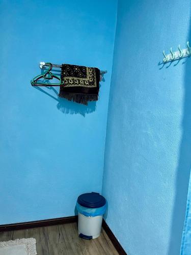 a blue room with a trash can and a blue wall at Avina's Standard Room in Setiu