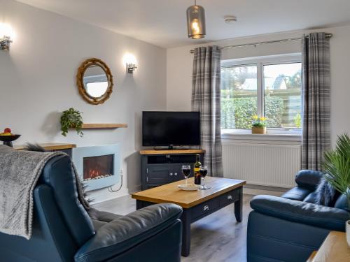 a living room with a couch and a tv at Anchor Cottage in Portpatrick