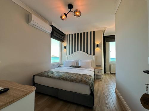 a bedroom with a large bed with a large window at Beyaz Ev Otel Restaurant in Eskiömerler
