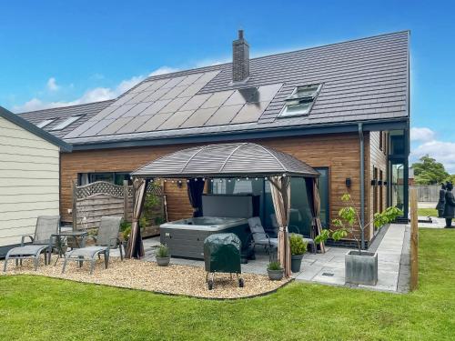 a backyard with a barbecue under a gazebo at The Paddocks Retreat in North Thoresby