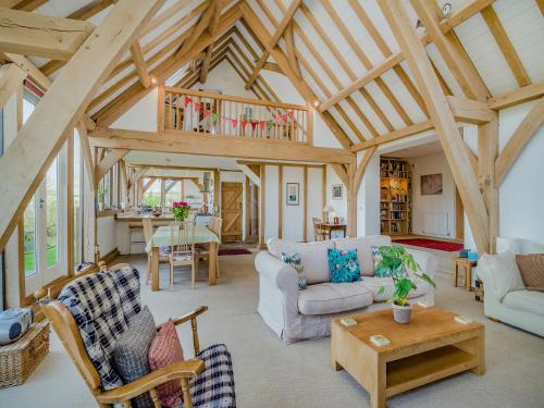 a living room with wooden ceilings and a table at Wylye Croft in Upwey