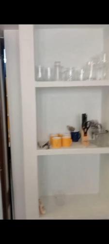 a white shelf with bowls and other items on it at CHIC yellow 2bhk- Just 10 Mins to Beach and WhiteTown DAWN in Puducherry
