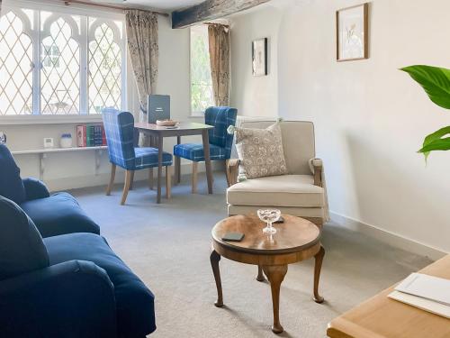 a living room with a blue couch and a table at The Knights Apartment, Eastbridge Hospital in Canterbury