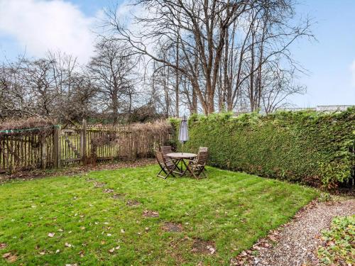 a table and chairs in a yard with a fence at Isla Bank Cottage in Keith