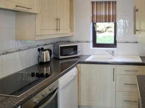 a kitchen with a microwave and a sink at Villa 55 in Cromer