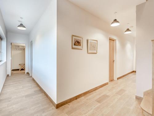 an empty room with white walls and wood floors at Hollyhocks - Uk47975 in Woodford