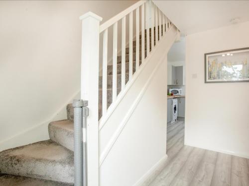 a staircase in a home with white walls and wood floors at Number 13 in Gunnislake