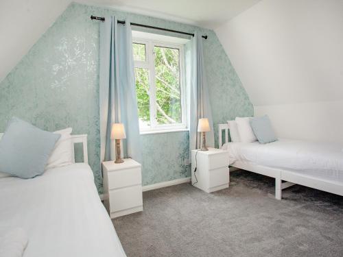 a bedroom with two beds and a window at Number 13 in Gunnislake