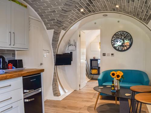 a kitchen and living room with a table and chairs at The Hobbit House in Hastingleigh