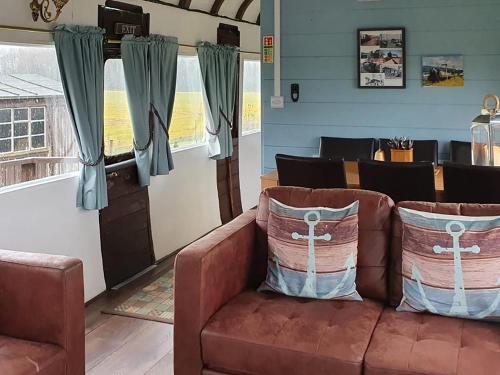 a living room with a brown couch and chairs at Elsie in Blue Anchor