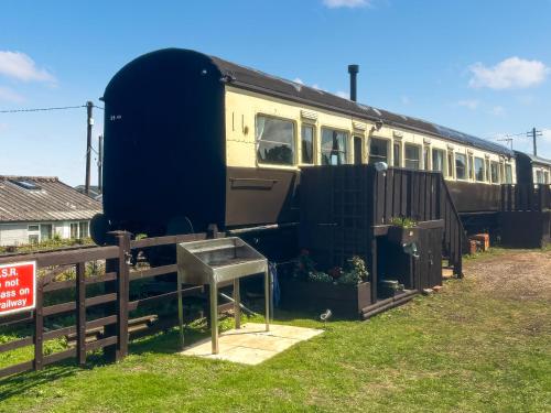 a train is parked next to a fence at Elsie in Blue Anchor