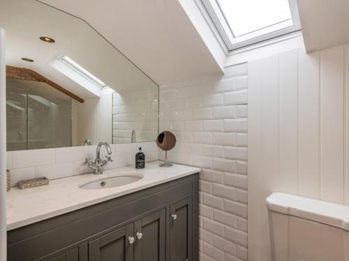 een badkamer met een wastafel en een spiegel bij Clematis Cottage in Thorpe Market