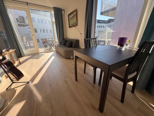 ein Wohnzimmer mit Tisch und großem Fenster in der Unterkunft JR apartments in Reykjavík