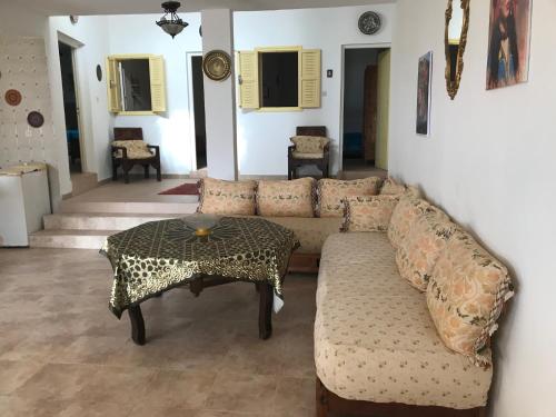 a living room with a couch and a table at Villa des Jasmins - Aghroude in Aghroude