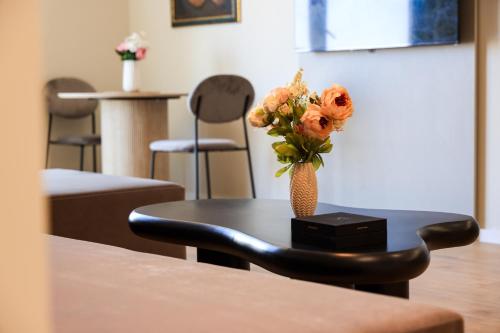 a table with a vase of flowers on it at Giselle Escape in Tirana