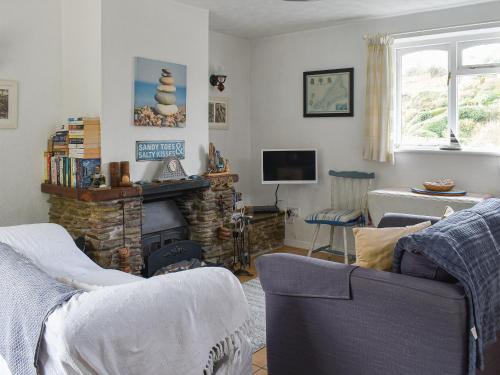a living room with a couch and a fireplace at Garden Cottage - Uk30590 in Polperro