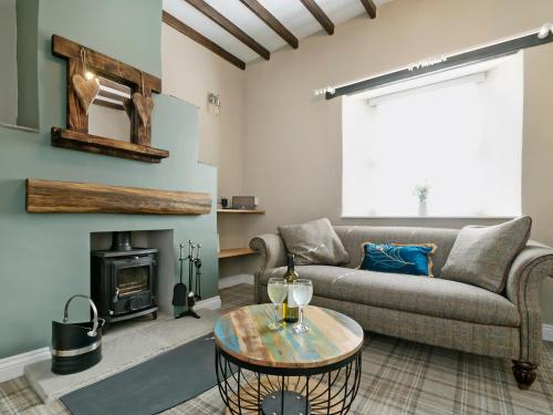 a living room with a couch and a fireplace at Pinfold Cottage in Richmond