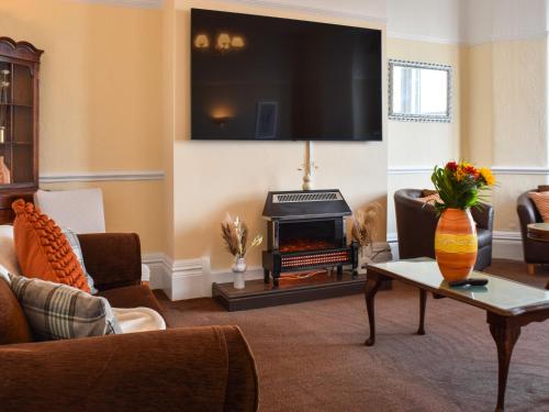 Una sala de estar con chimenea y televisión. en Drumford, en Blackpool