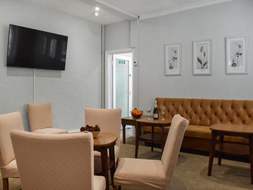 Una sala de estar con un sofá y una mesa con sillas. en Drumford, en Blackpool