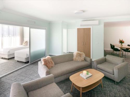 a living room with a couch and a bed at The Sebel Kiama in Kiama