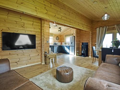 a living room with a large flat screen tv on a wooden wall at Stag Lodge - Uk46921 in Falkirk