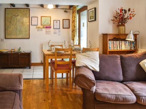 a living room with a couch and a table at Church House Cottage in Ulpha