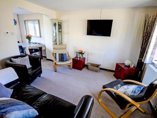 ein Wohnzimmer mit Sofa und Fernseher in der Unterkunft The Yellow House in Padstow