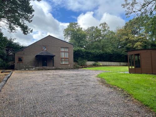 a large brick house with a gravel driveway at Dunsdale Lodge in Frodsham