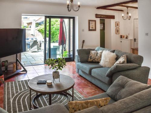 a living room with a couch and a table at Shetland Cottage in Stalham