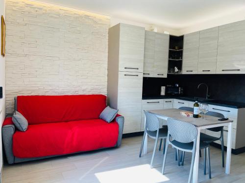 a living room with a red couch and a table at Garda Art&City - near Sigurtà and Borghetto in Valeggio sul Mincio