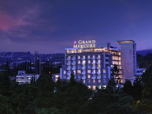 a building with a sign on top of it at night at Grand Mercure Bandung Setiabudi in Bandung