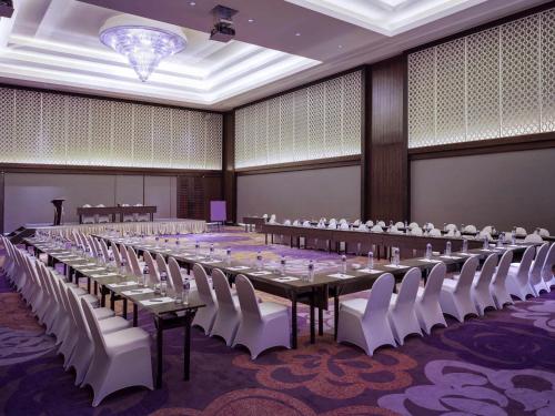 a large banquet hall with tables and white chairs at Grand Mercure Bandung Setiabudi in Bandung