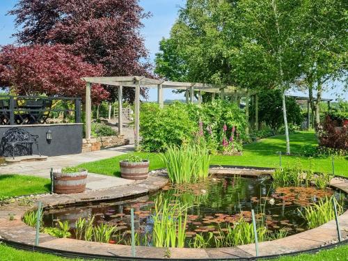 a garden with a pond and a gazebo at Beacon Cottage in Ivegill