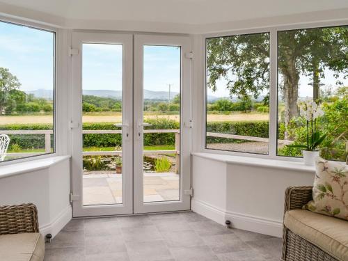 a living room with french doors and windows at Beacon Cottage in Ivegill