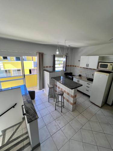 a kitchen with white appliances and a counter top at Pousada Village in Florianópolis