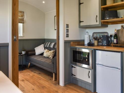 a living room with a couch in a kitchen at Meadows View Shepherd's Hut in Cockermouth