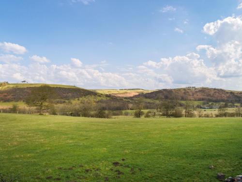 a large green field with hills in the background at Meadows View Shepherd's Hut in Cockermouth