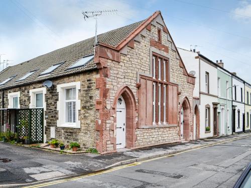 an old brick building on the side of a street at Chapel Mouse Cottage in Cockermouth