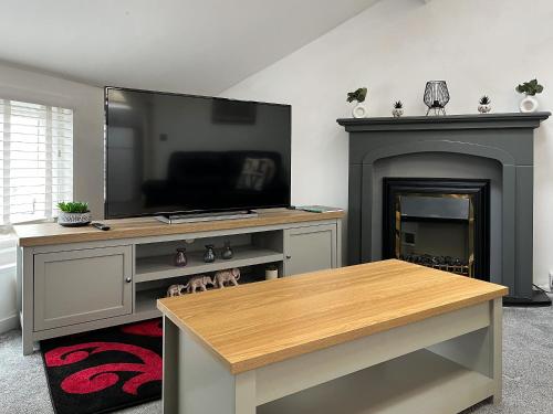 a living room with a tv and a fireplace at Regent House in Scarborough