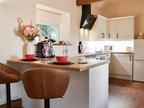 a kitchen with a counter with red bowls on it at The Stables At Grange Barn in Rise