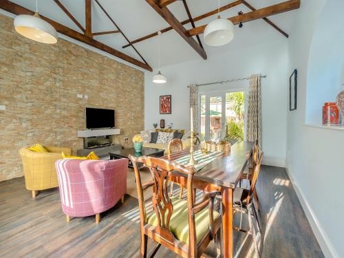 ein Esszimmer und ein Wohnzimmer mit Tisch und Stühlen in der Unterkunft Blofield Cottage - Uk48095 in Norwich