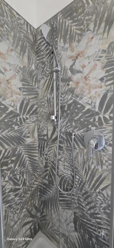 a shower in a bathroom with a black and white wallpaper at Orchidea Stazione in Bologna
