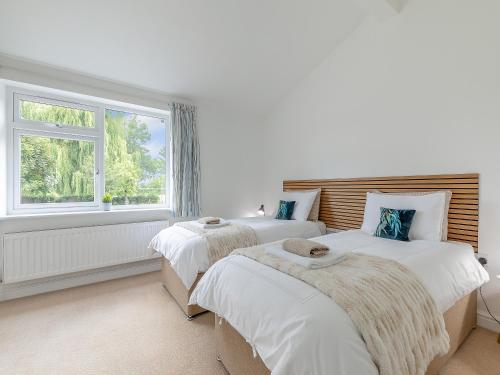 two beds in a white room with a window at The Crofts in Winsford
