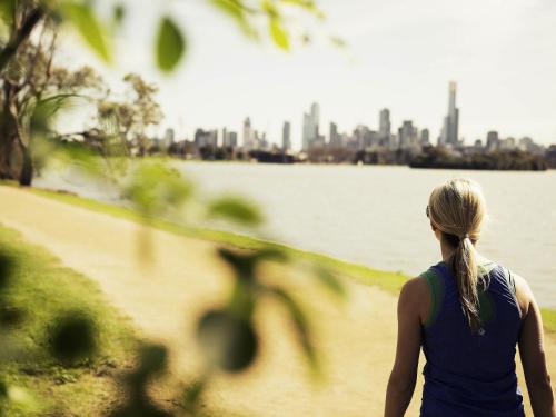 a woman standing next to a body of water at Mercure Melbourne Albert Park in Melbourne
