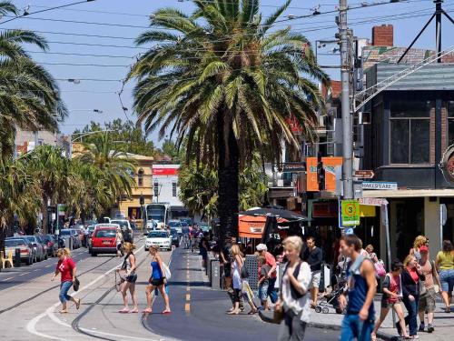 a group of people crossing a busy city street at Mercure Melbourne Albert Park in Melbourne